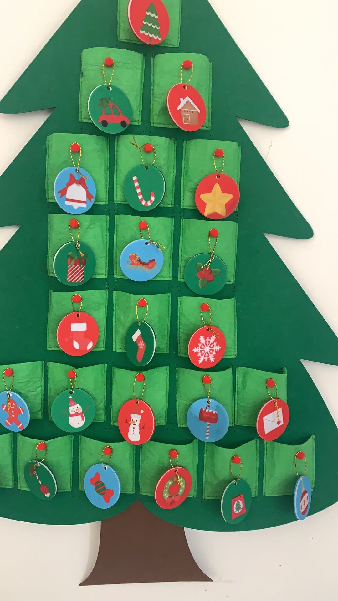 Close-up of felt pockets, red buttons and decorative hanging discs