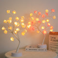 Touch-control LED rose tree lamp illuminated on a tabletop