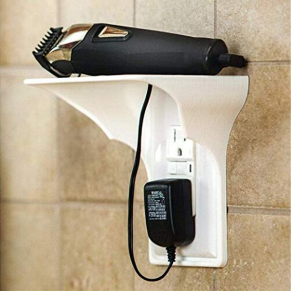 Wall outlet organiser shelf holding a phone while charging