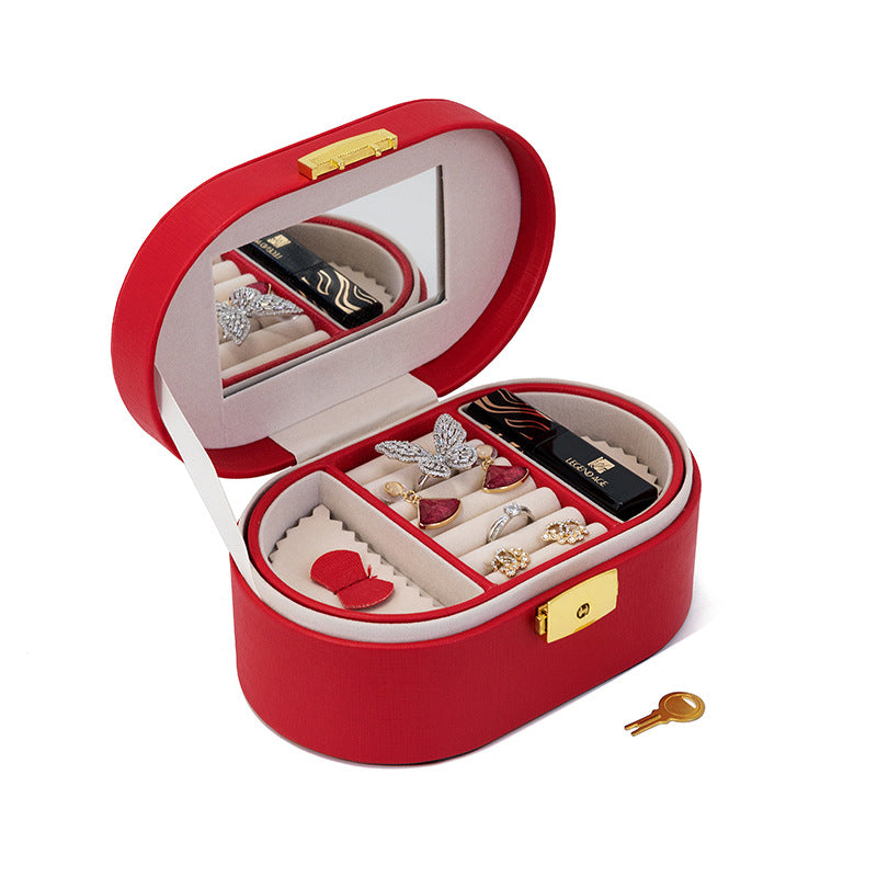 Red oval jewellery case open with mirror and tray