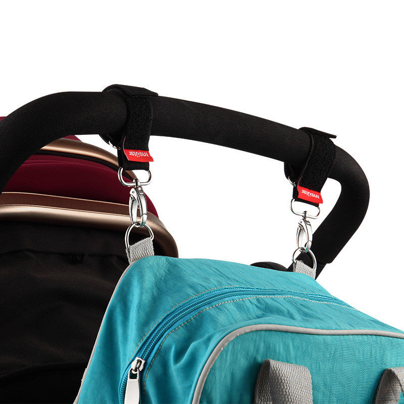 Two swivel hooks securing a bag to a pram handle